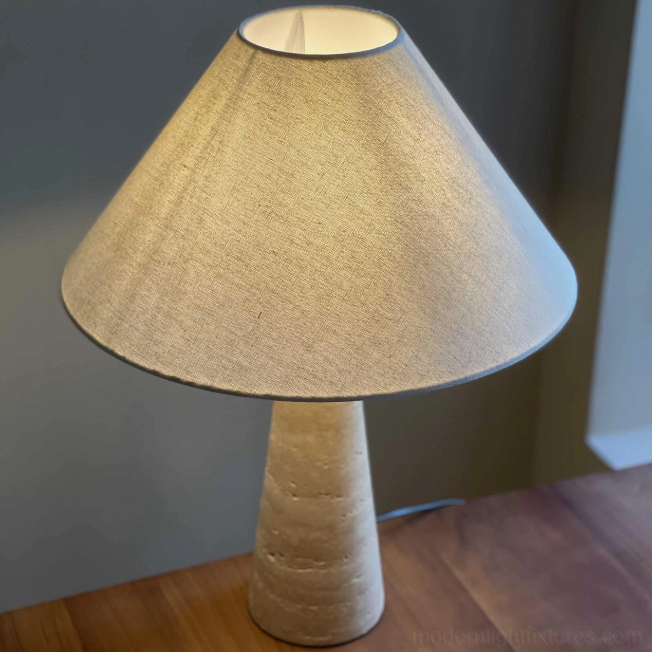 Lulu travertine table lamp on white nightstand in contemporary master bedroom showing warm fabric shade illumination