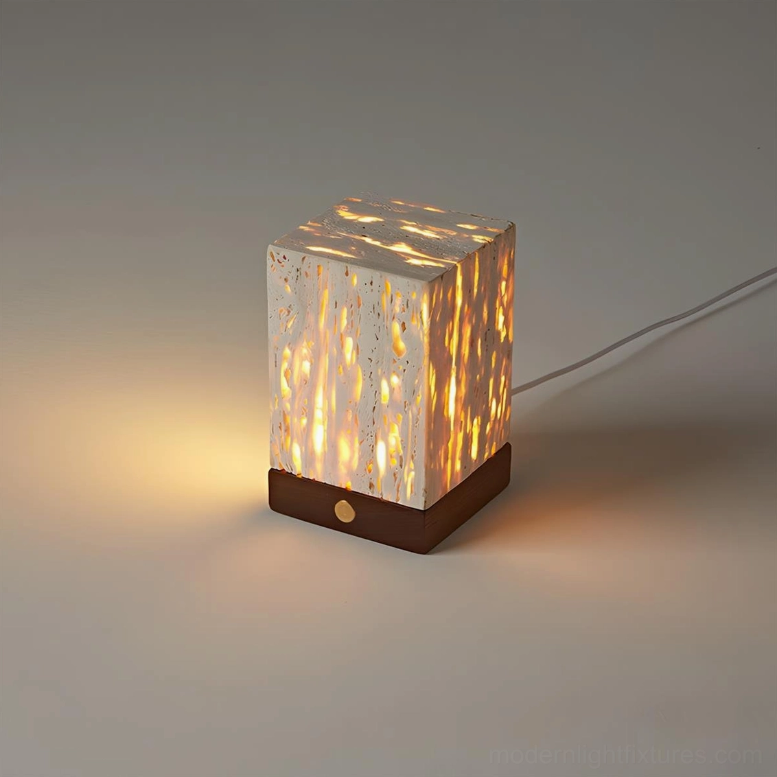 Modern travertine table lamp three-quarter view glowing LED warm white light