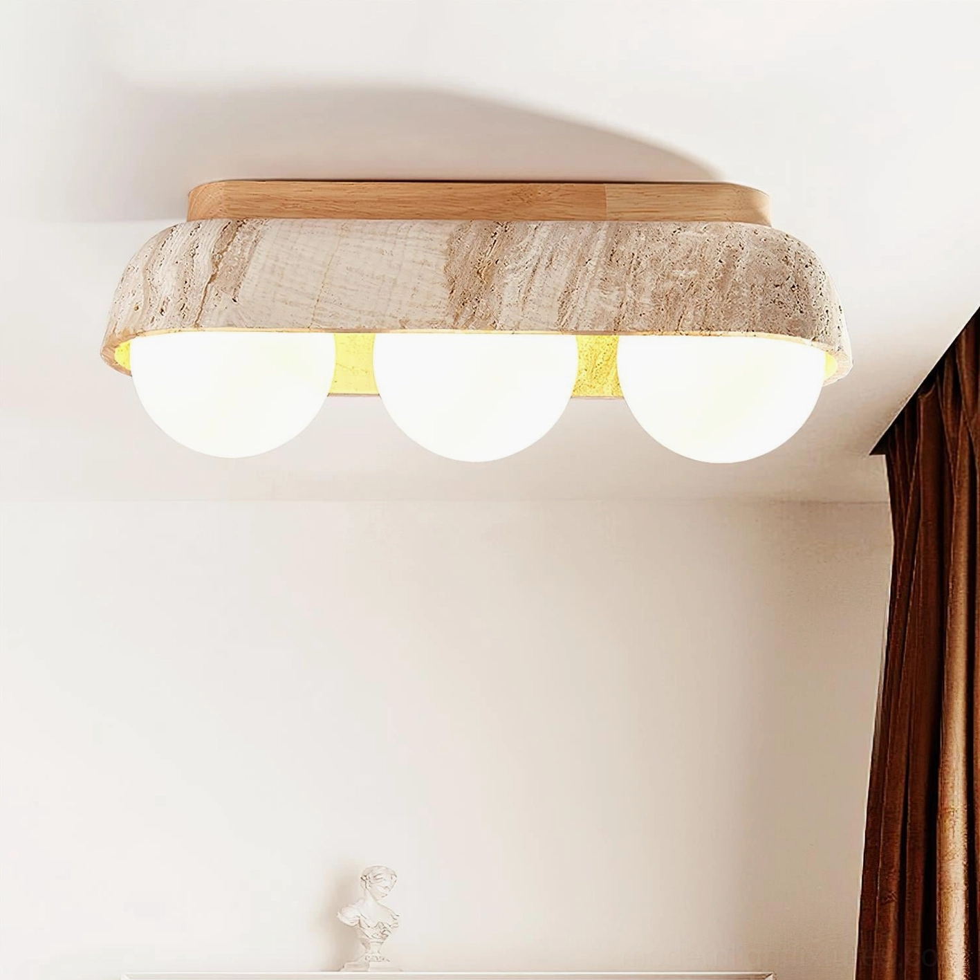 Travertine ceiling light fixture installed upward view showing warm glowing spheres and light wood mounting canopy