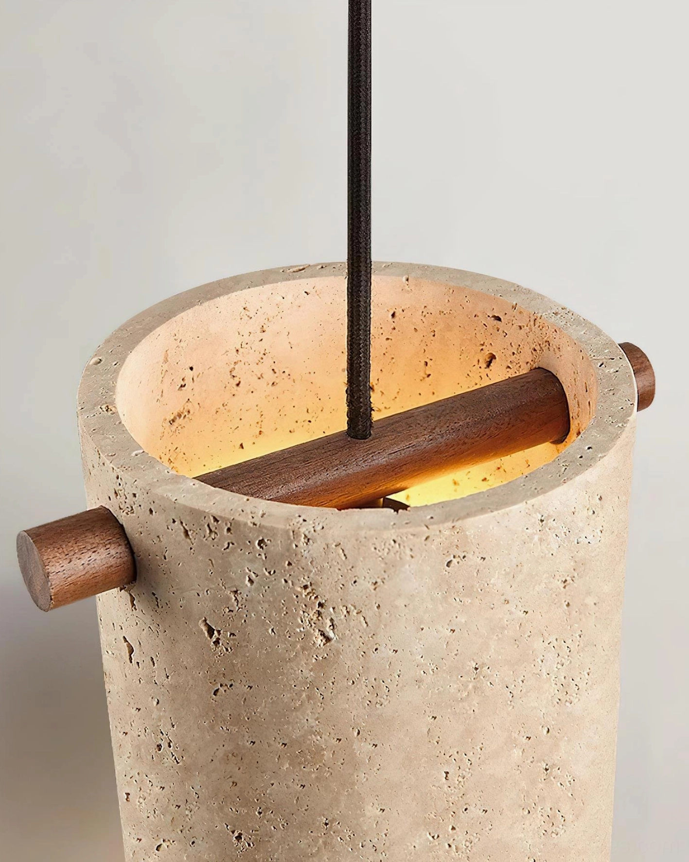 Close-up top view of travertine pendant lamp interior showing wooden cross bar and natural stone surface