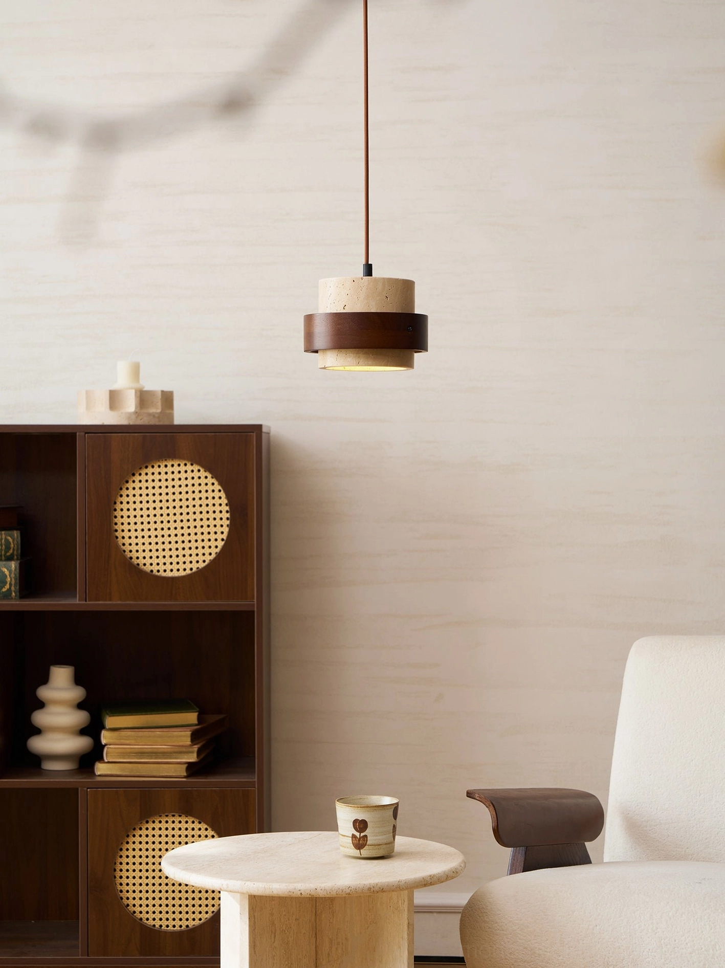 Natural stone travertine pendant light with warm amber illumination, showing diffused glow through porous stone