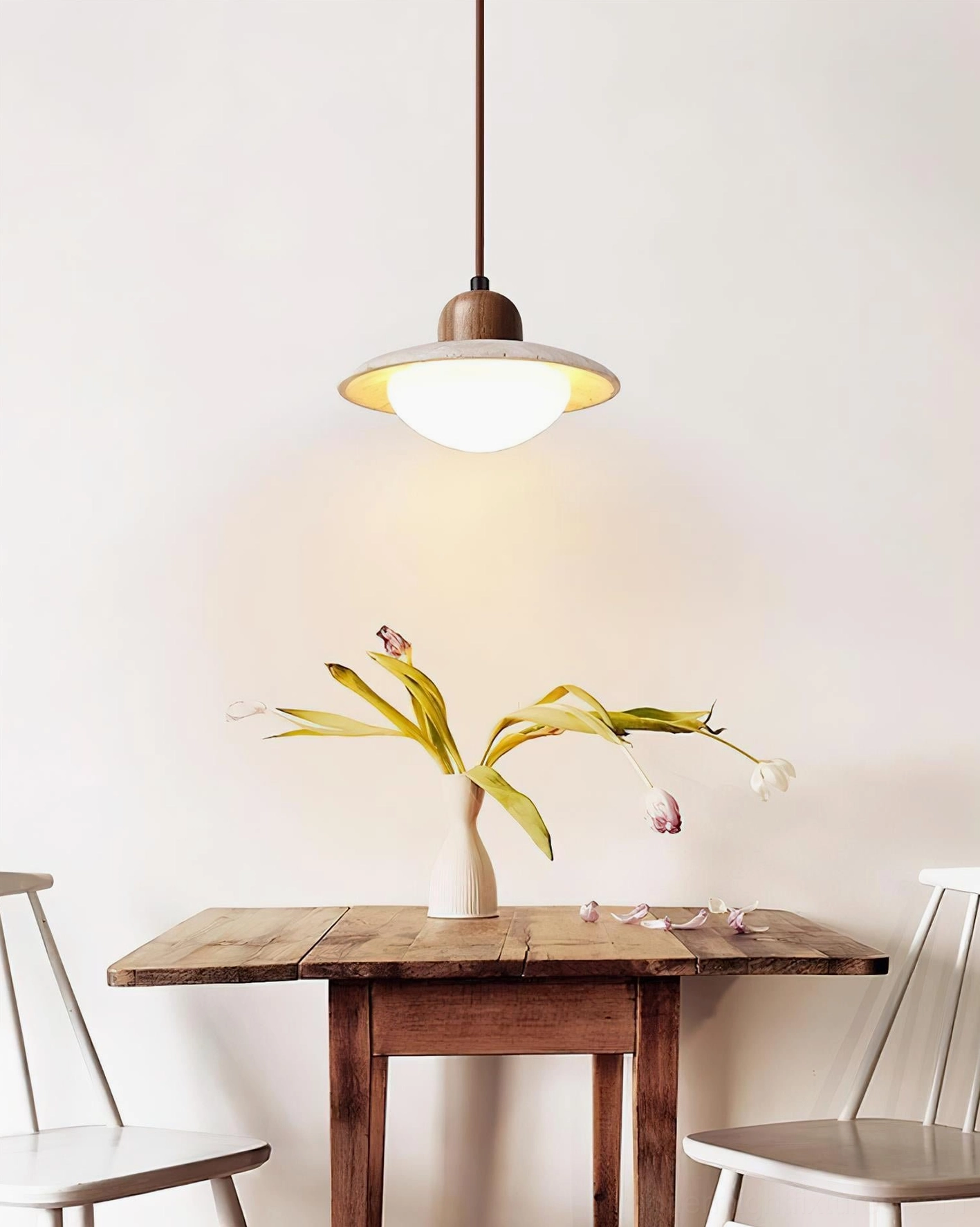 Single travertine stone pendant lamp above modern minimalist dining nook