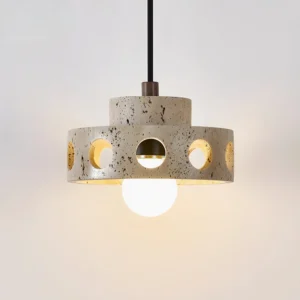 Illuminated travertine pendant lamp showing warm light glow through circular cutouts and gold-trimmed interior socket