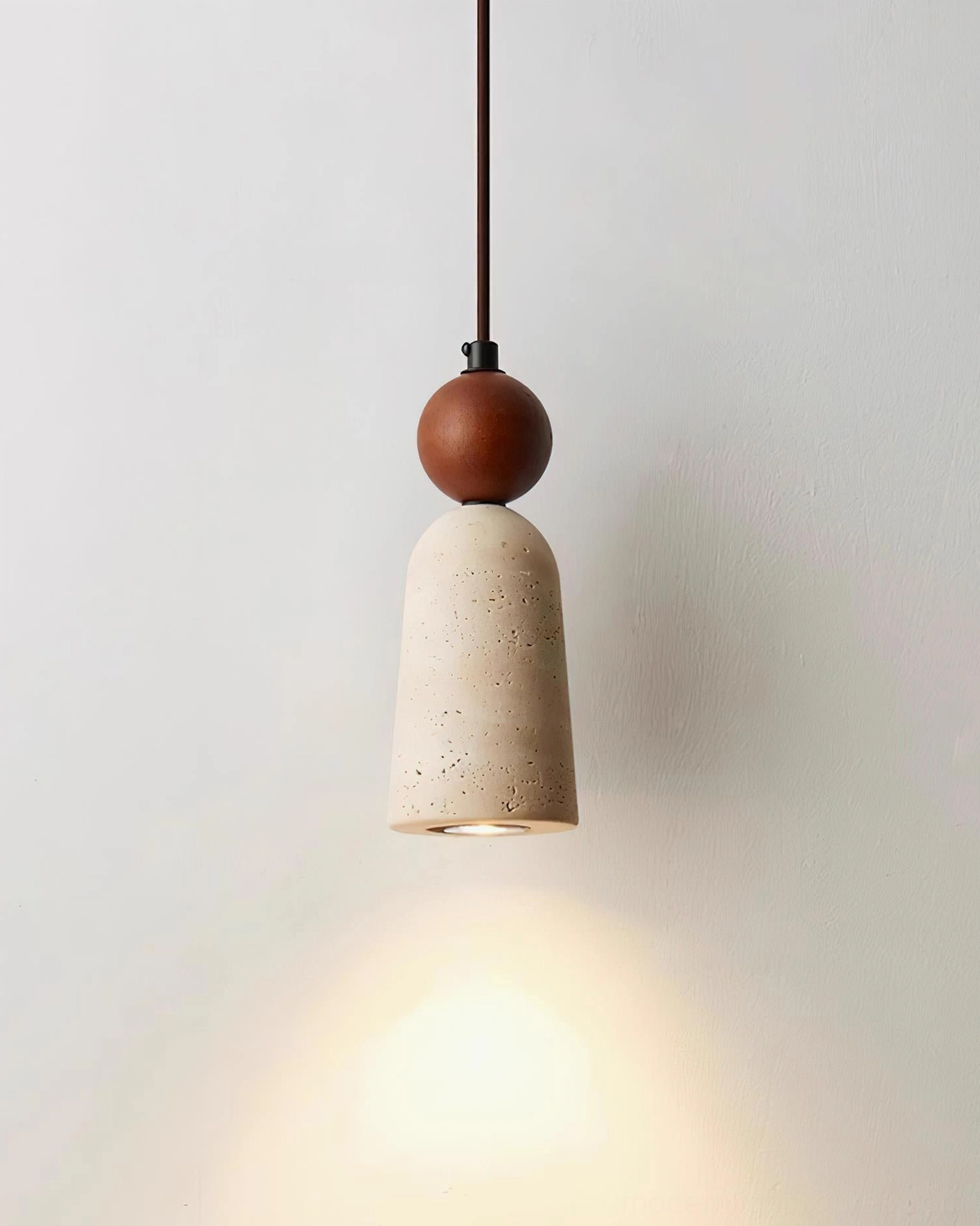 Architectural detail view of Bellin pendant fixture showing travertine texture and wood sphere accent