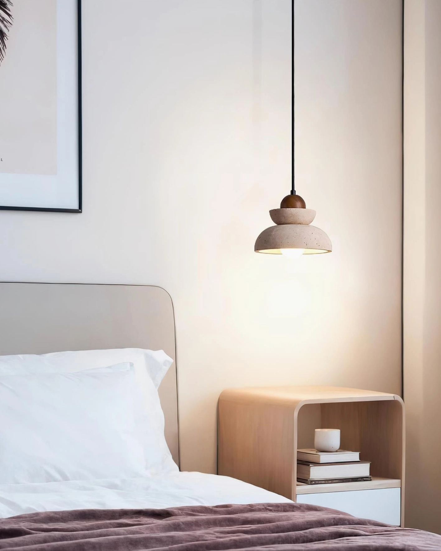 Modern stone pendant light hung above bed in minimalist bedroom with warm ambient glow