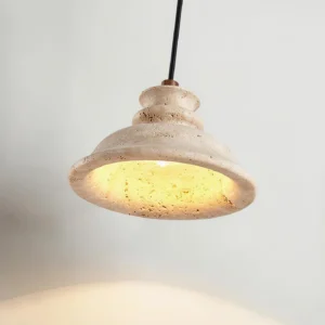 Illuminated travertine pendant lamp casting warm glow with textured stone surface detail and black cord