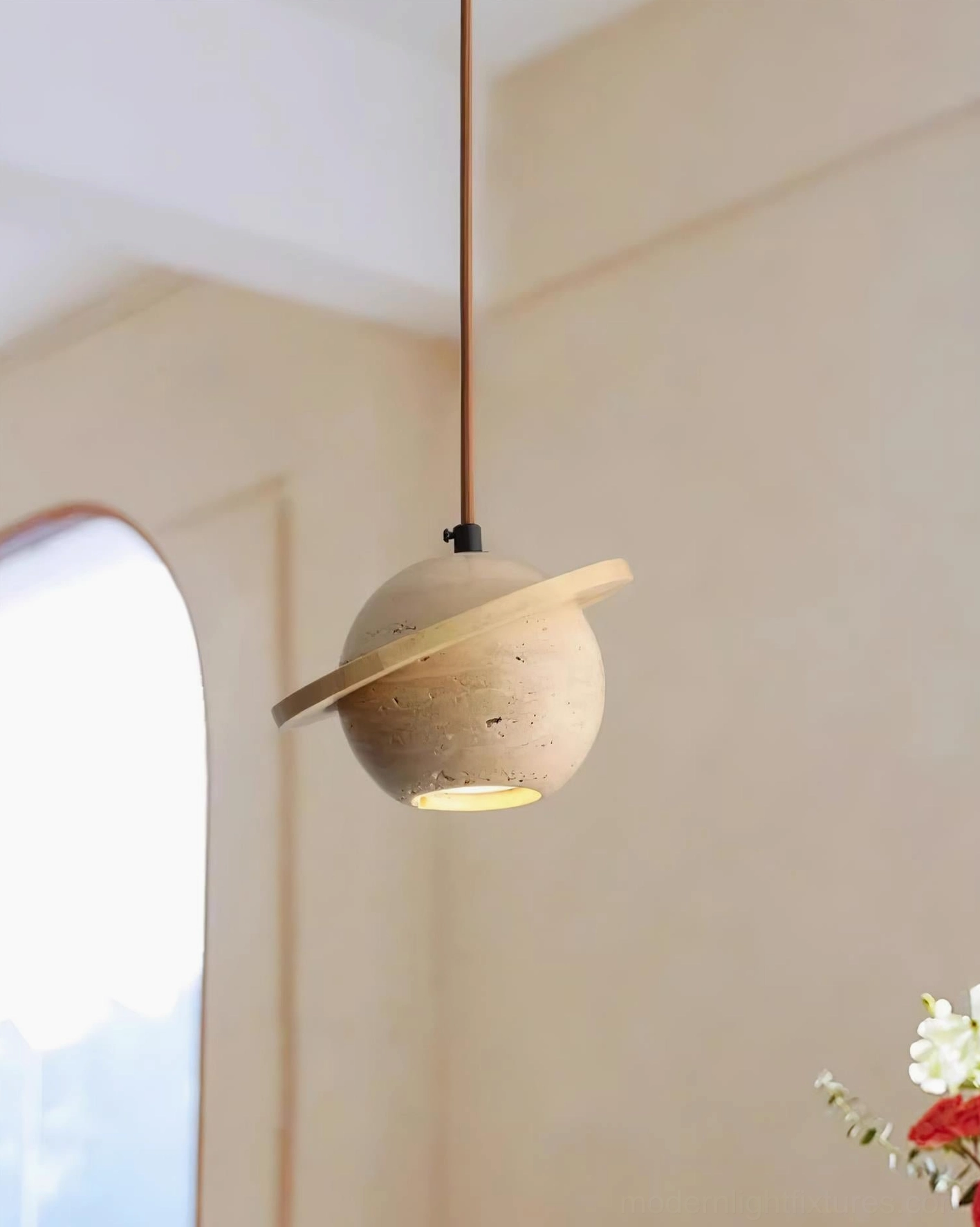 Travertine sphere pendant light in minimalist modern space, geometric form creating artistic statement piece