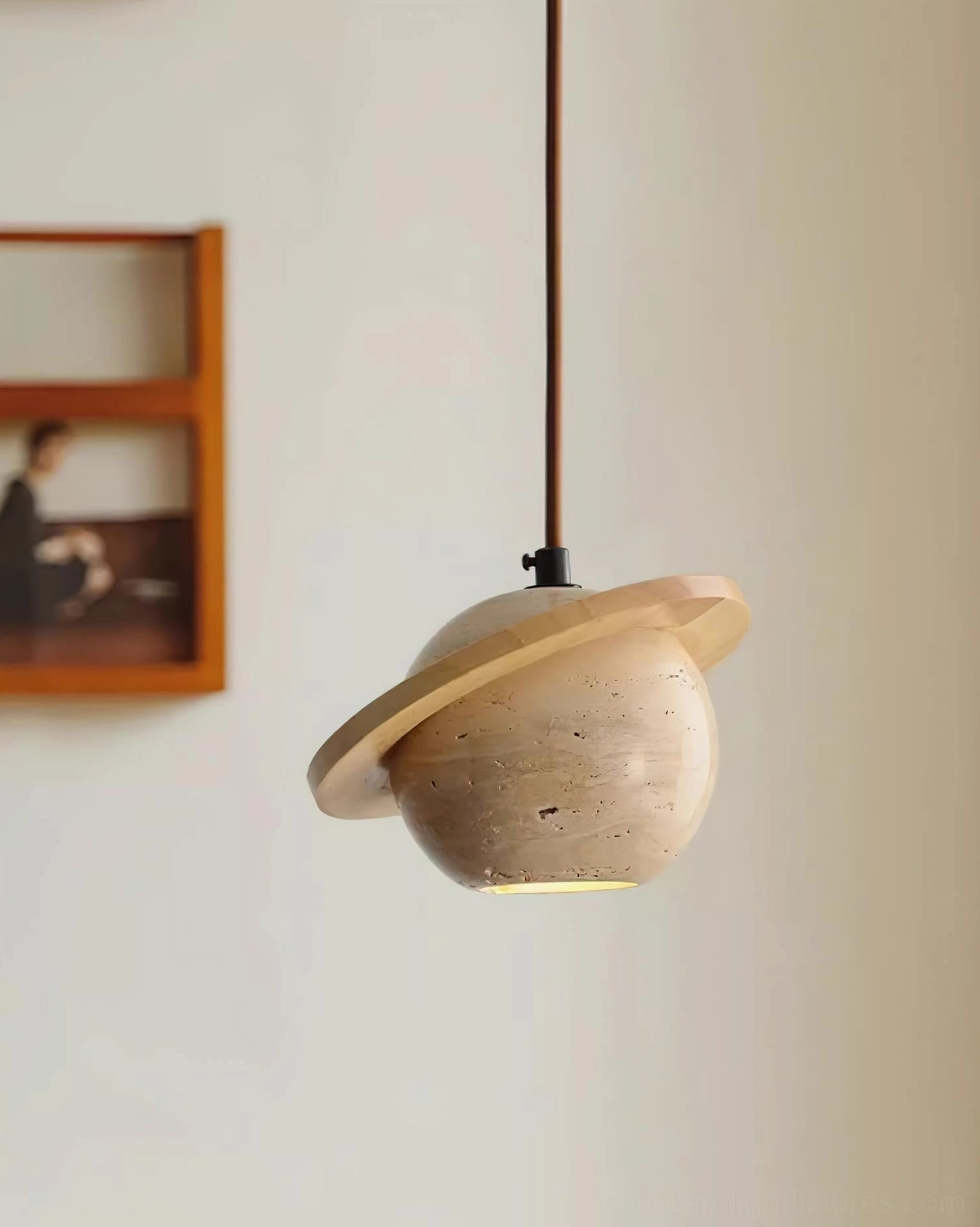 Travertine sphere pendant light installed in residential interior, side profile showing warm ambient glow against wooden wall