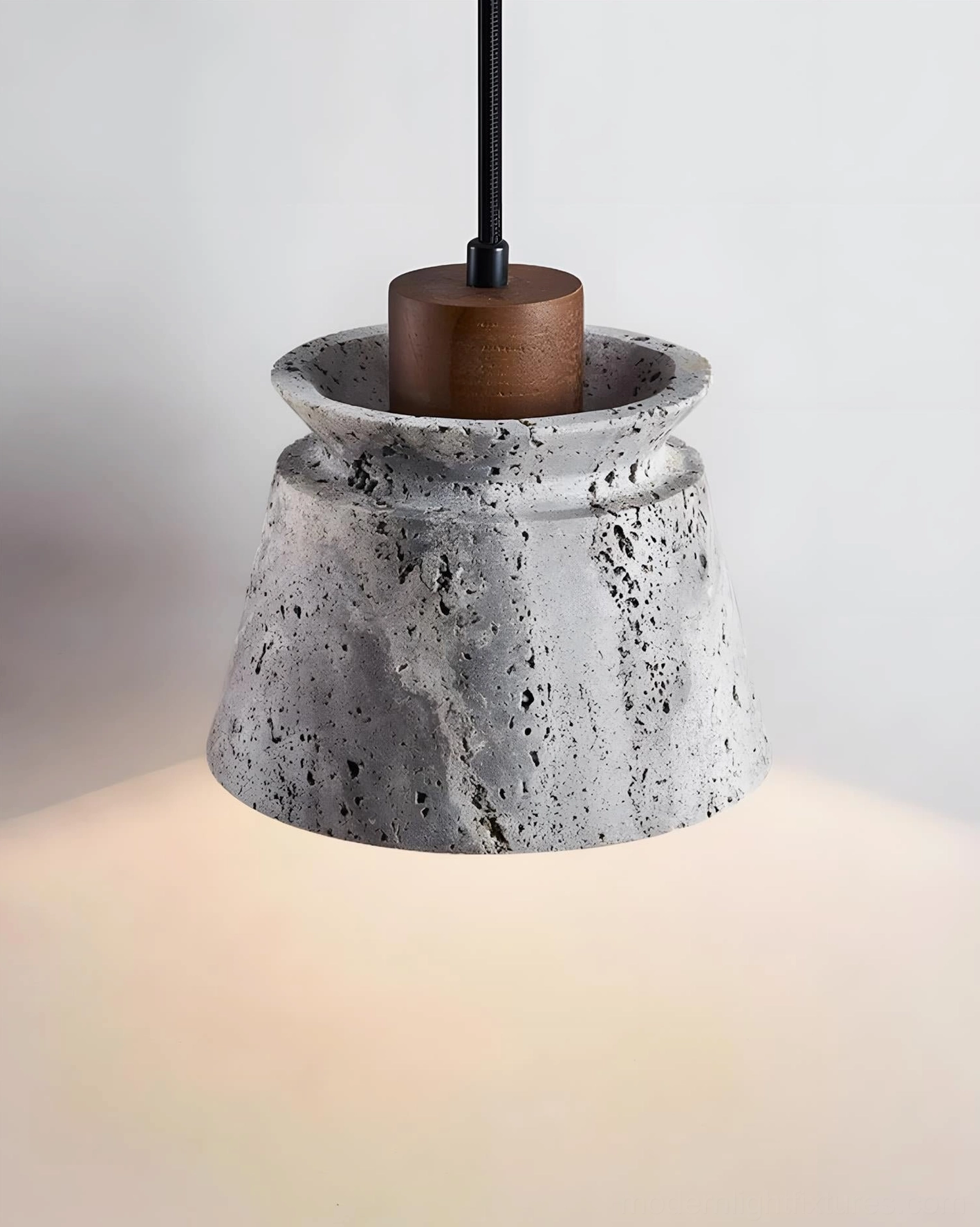 Travertine pendant light suspended installation showing warm directed light and architectural sculptural form