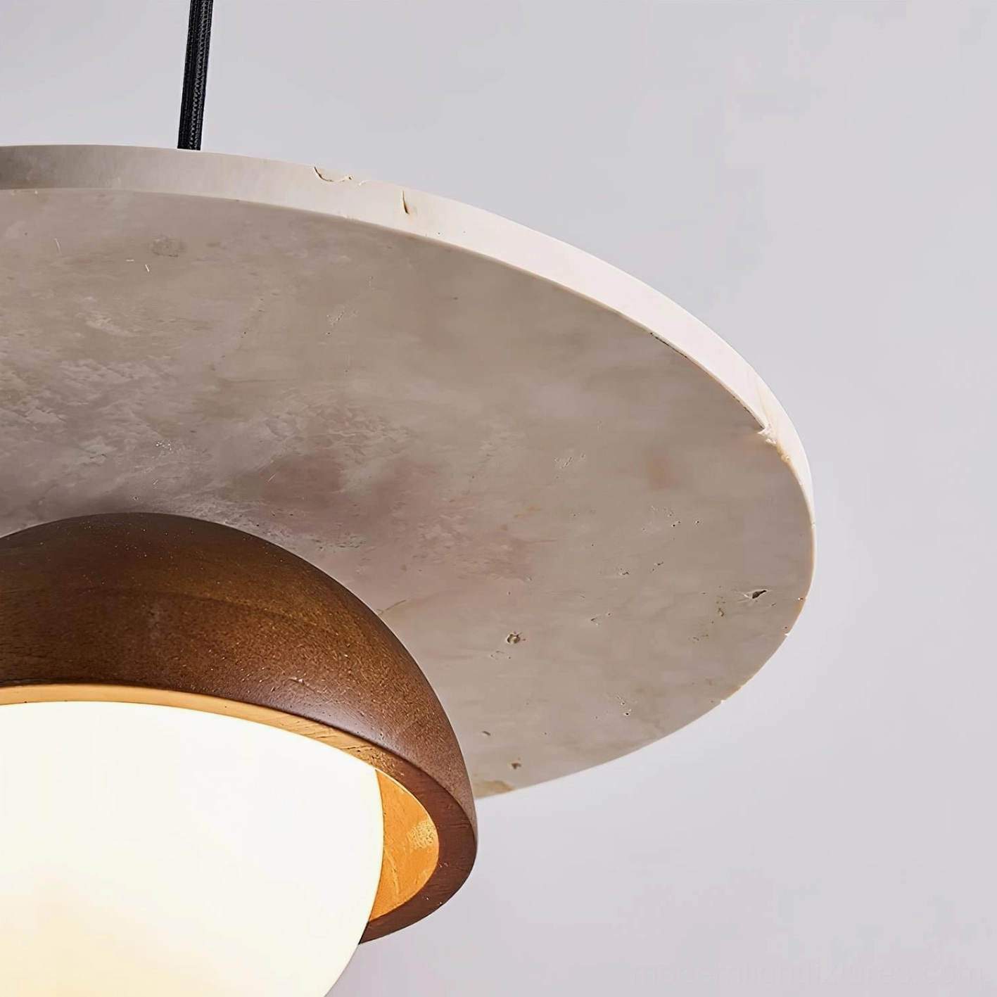 Modern ceiling pendant light with travertine and glass showing warm light diffusion effect