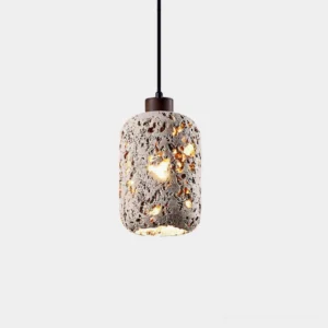 Travertine cylinder pendant light with warm glowing porous stone shade and dark hanging cord on white background