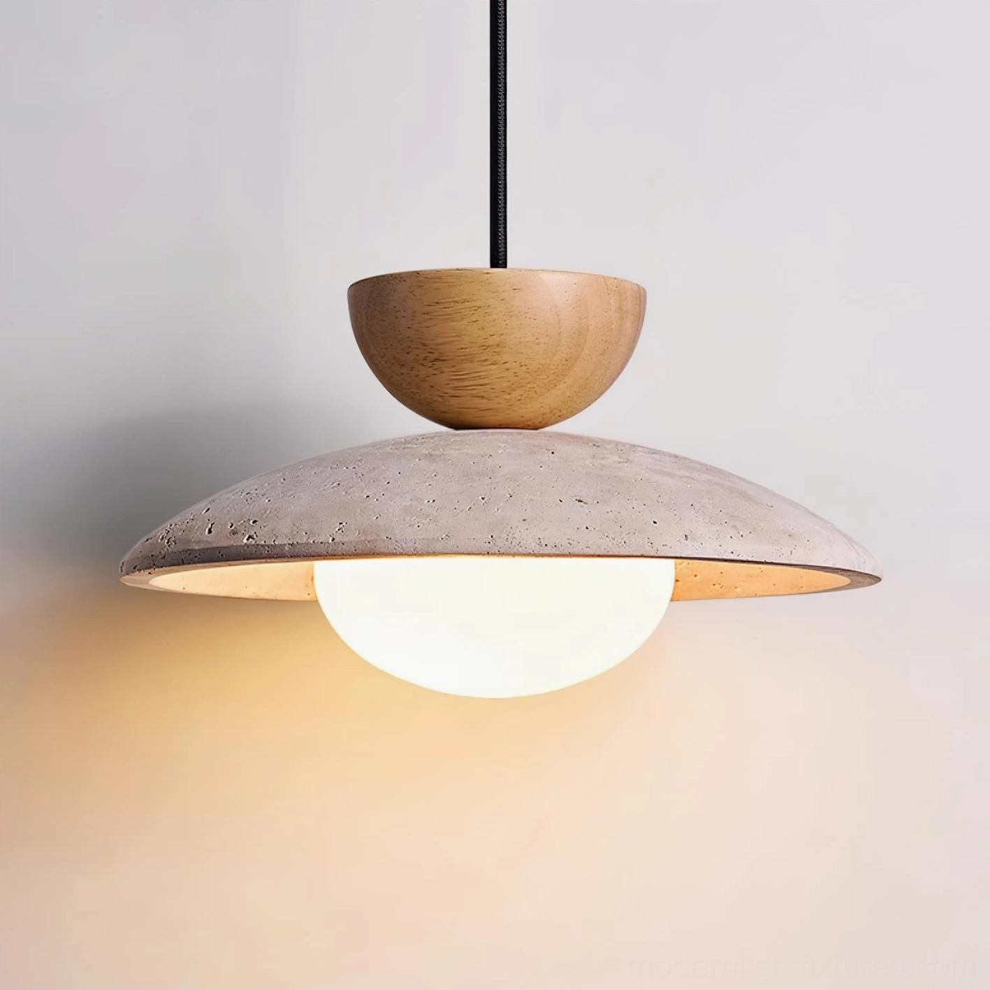 Tia natural travertine pendant light showing warm glow and halo effect from frosted glass