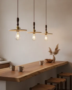 Set of three travertine disc pendant lights with gold accents and exposed bulbs in studio overhead view