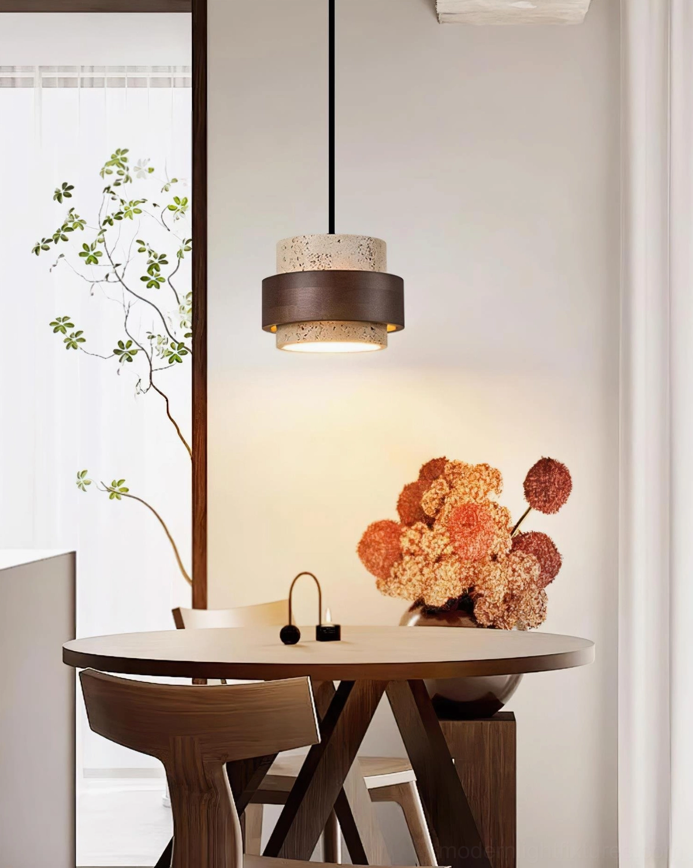 Single travertine pendant light in modern dining nook with plants creating wabi-sabi aesthetic