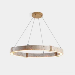 Travertine ring chandelier with warm LED light glowing inside circular stone frame, suspended by fine cables, front low-angle studio view