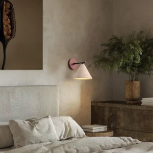Travertine wall sconce installed in master bedroom above nightstand - warm ambient reading light with natural stone fixture
