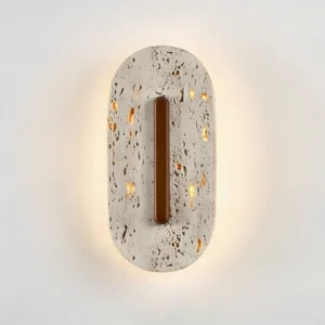Travertine wall sconce illuminated detail showing warm light emanating through natural stone pores and texture