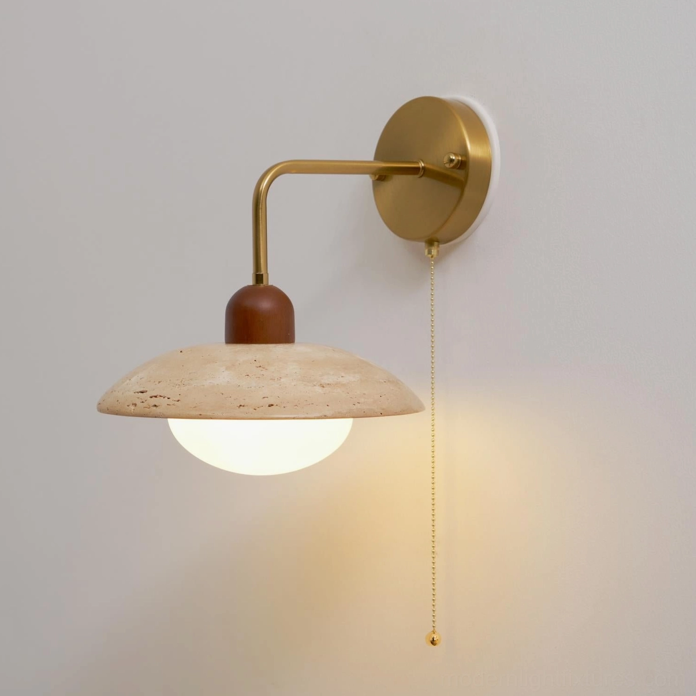 Close-up of travertine wall sconce showing natural stone pores and authentic material character