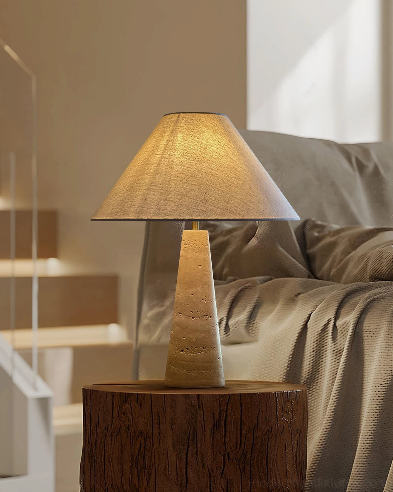 Minimalist travertine table lamp positioned beside modern fabric sofa on wooden side table in contemporary living room space