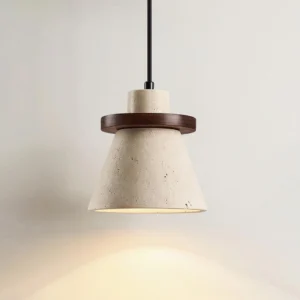 Single travertine stone pendant lamp emitting warm downward light against light gray wall