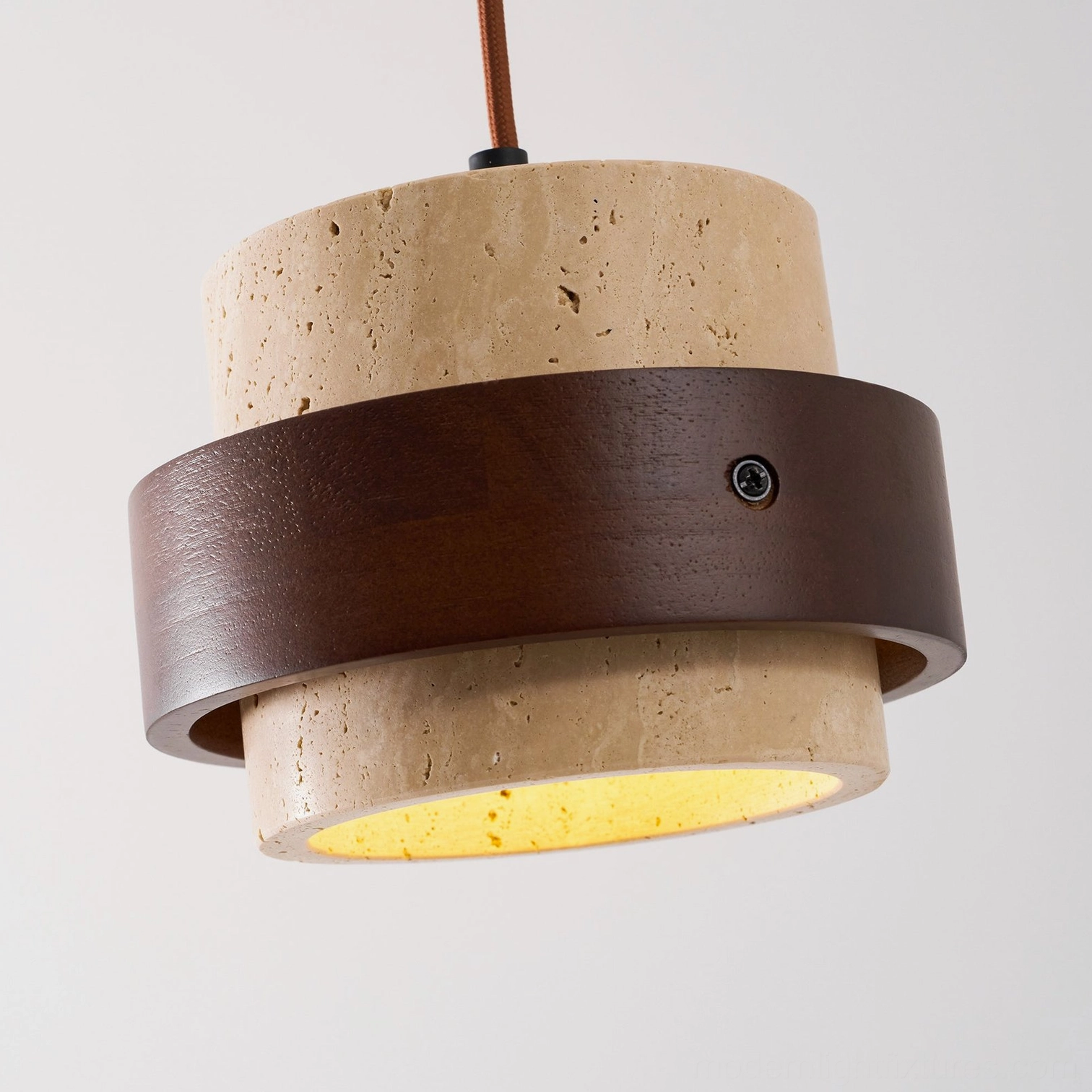 Travertine stone pendant light showing warm illumination through beige mineral stone, glow through-light effect
