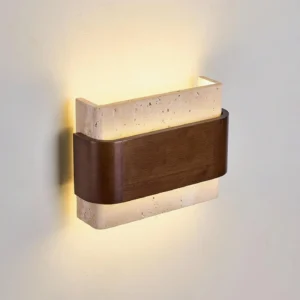 Travertine wall sconce three-quarter angle showing warm backlit glow and natural stone texture detail