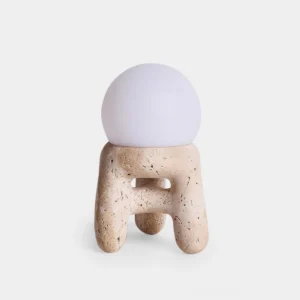Travertine stool table lamp with white frosted globe shade on studio white background, front flat view