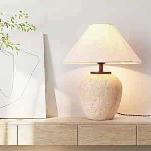 Travertine table lamp three-quarter angle view on wooden floating cabinet with minimalist backdrop