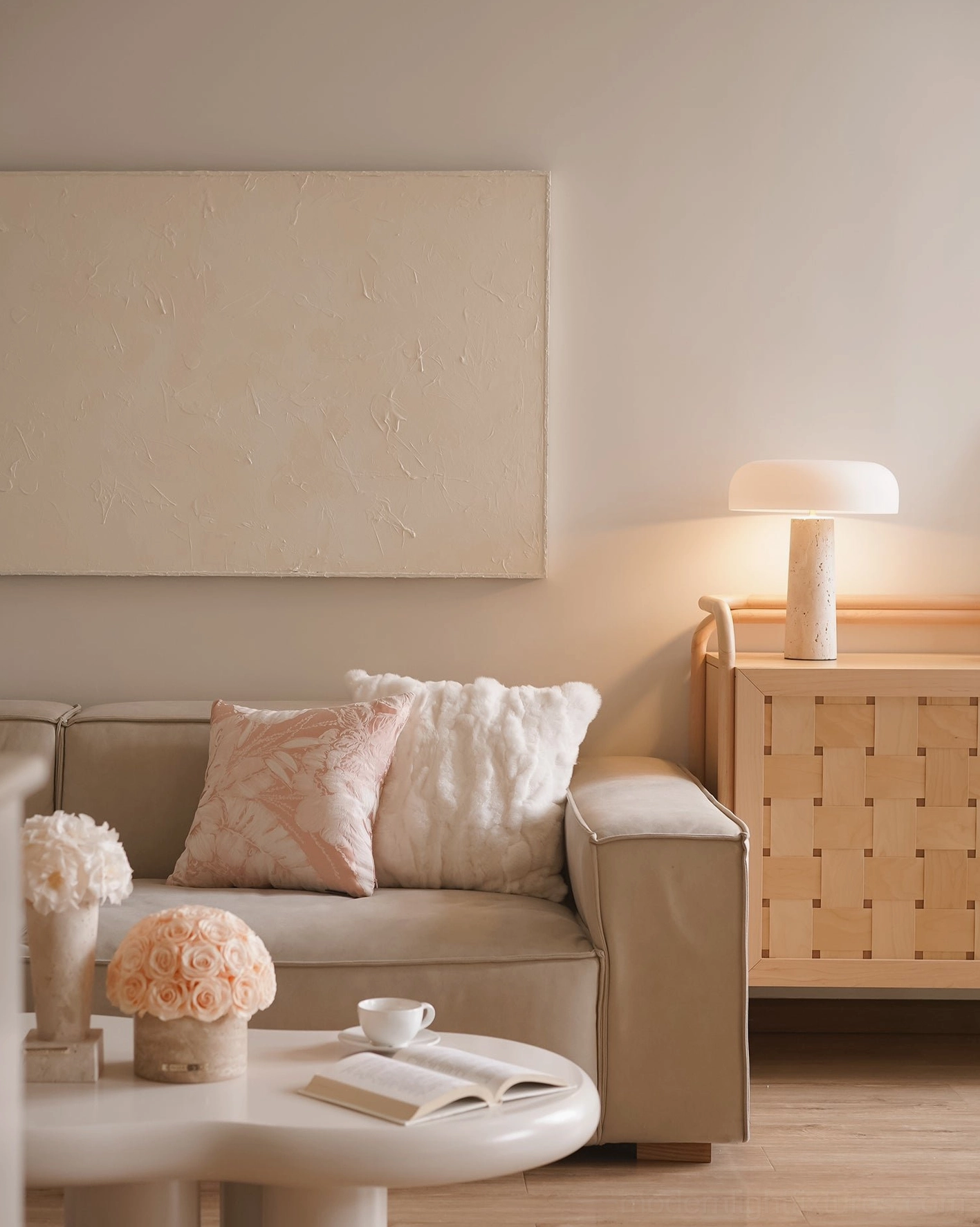 Travertine table lamp styled in modern living room on woven side cabinet, paired with sofa and bohemian decor