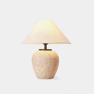 Modern travertine table lamp with textured stone base and cream fabric shade, front-facing product display