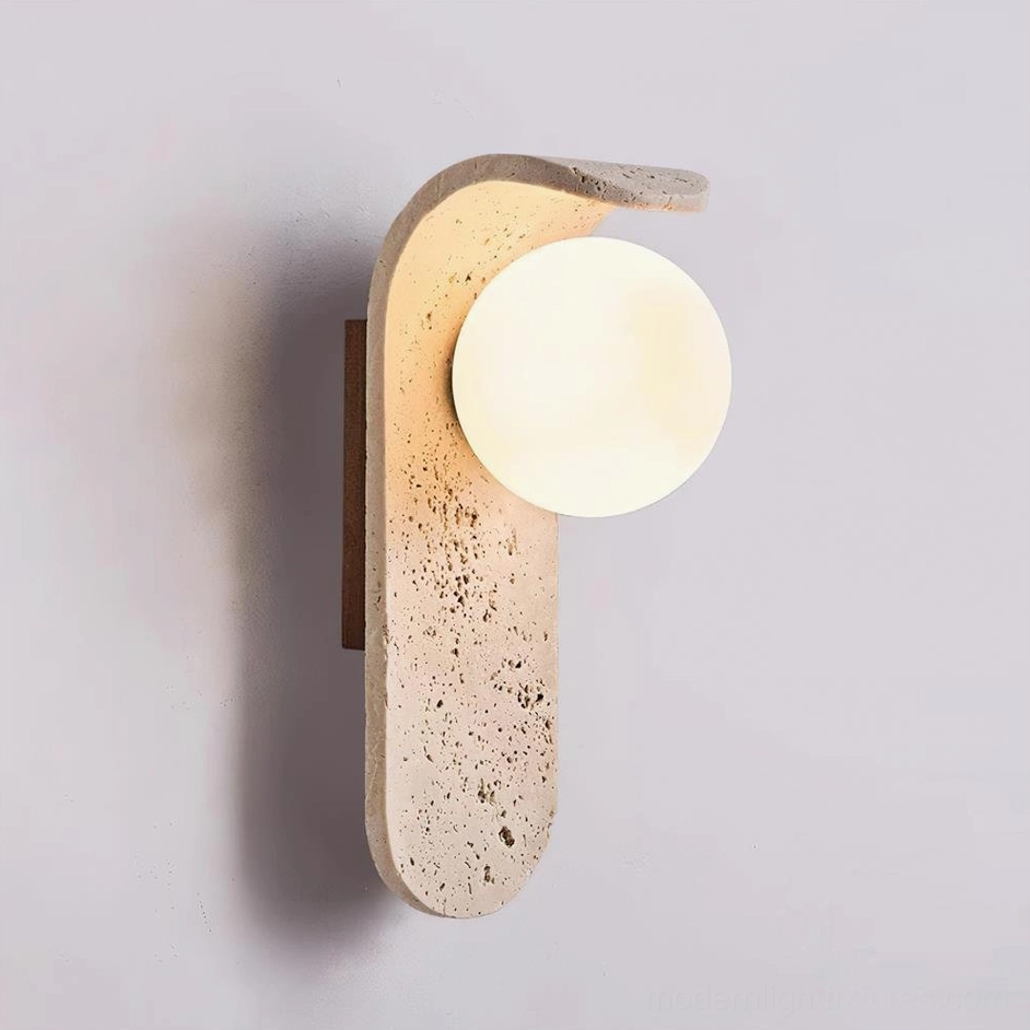Travertine wall lamp detail - frosted glass globe and sculptural stone base composition