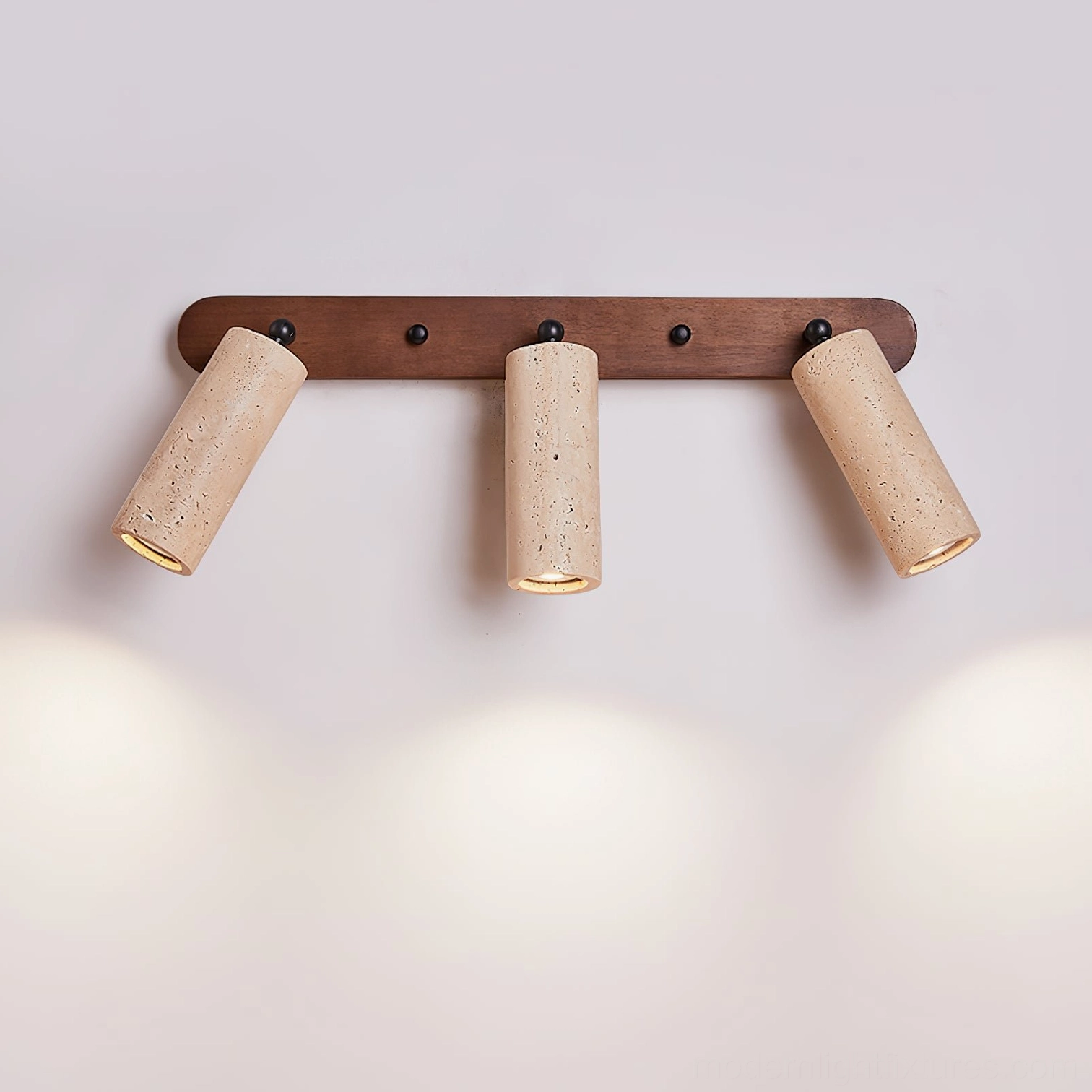 Ricerca 3-head travertine wall sconce side view mounted on wall with warm lighting effect and dark wood base
