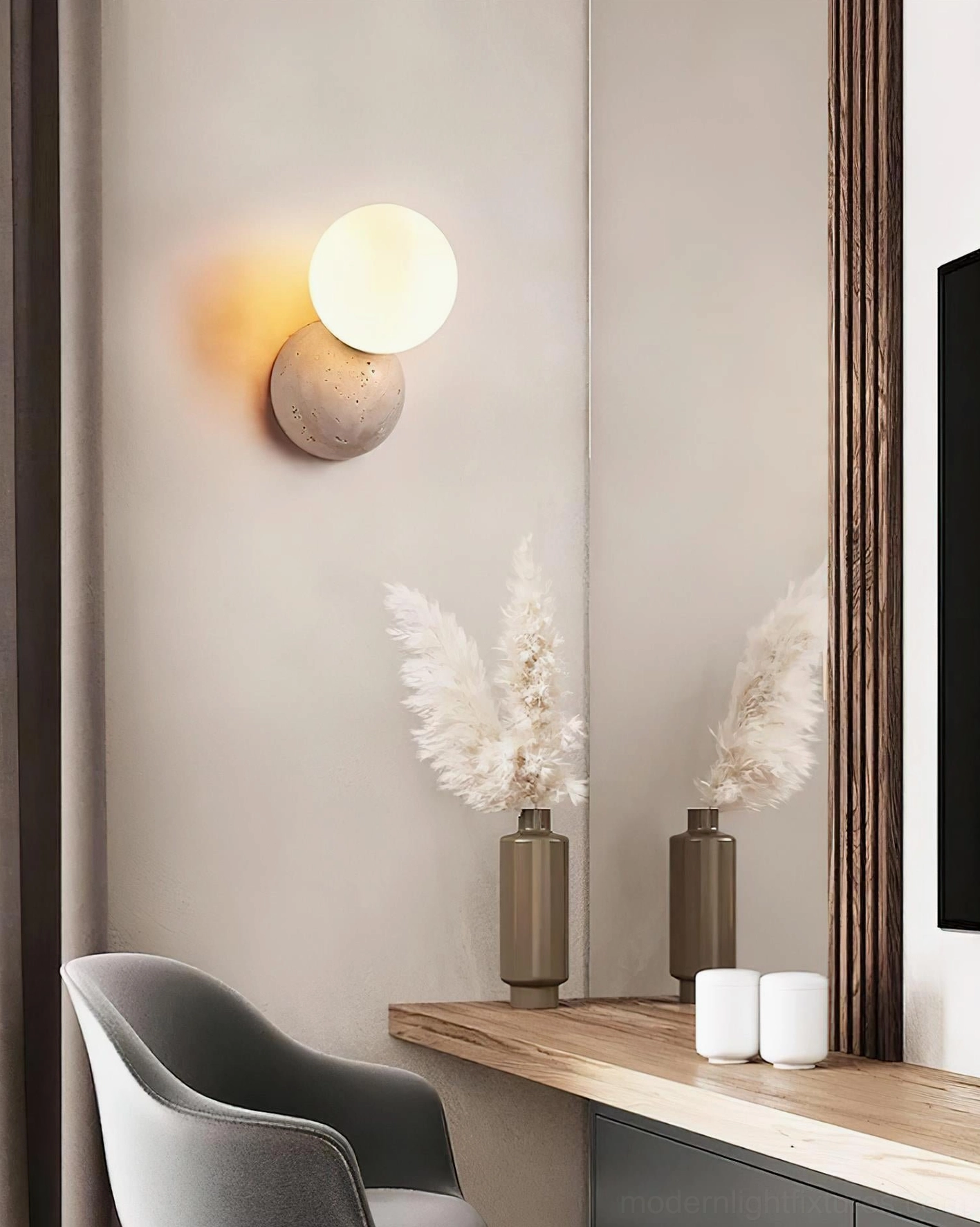 Travertine wall sconce above bathroom vanity mirror, warm neutral residential spa-inspired interior design