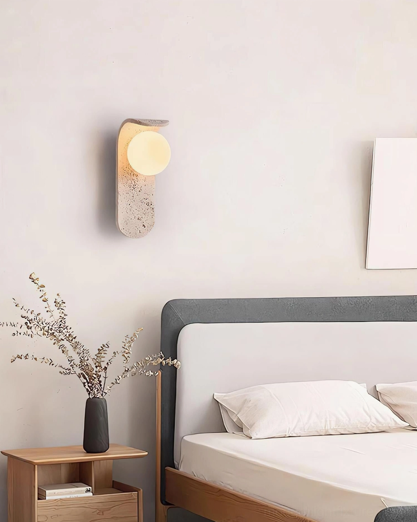 Travertine wall sconce installed in contemporary bedroom - side view with warm minimalist decor
