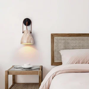 Modern travertine wall lamp with wood grain shade installed above bedroom bedside table