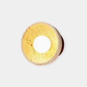 Modern travertine wall sconce with concave bowl-shaped stone shade and warm central light on white background