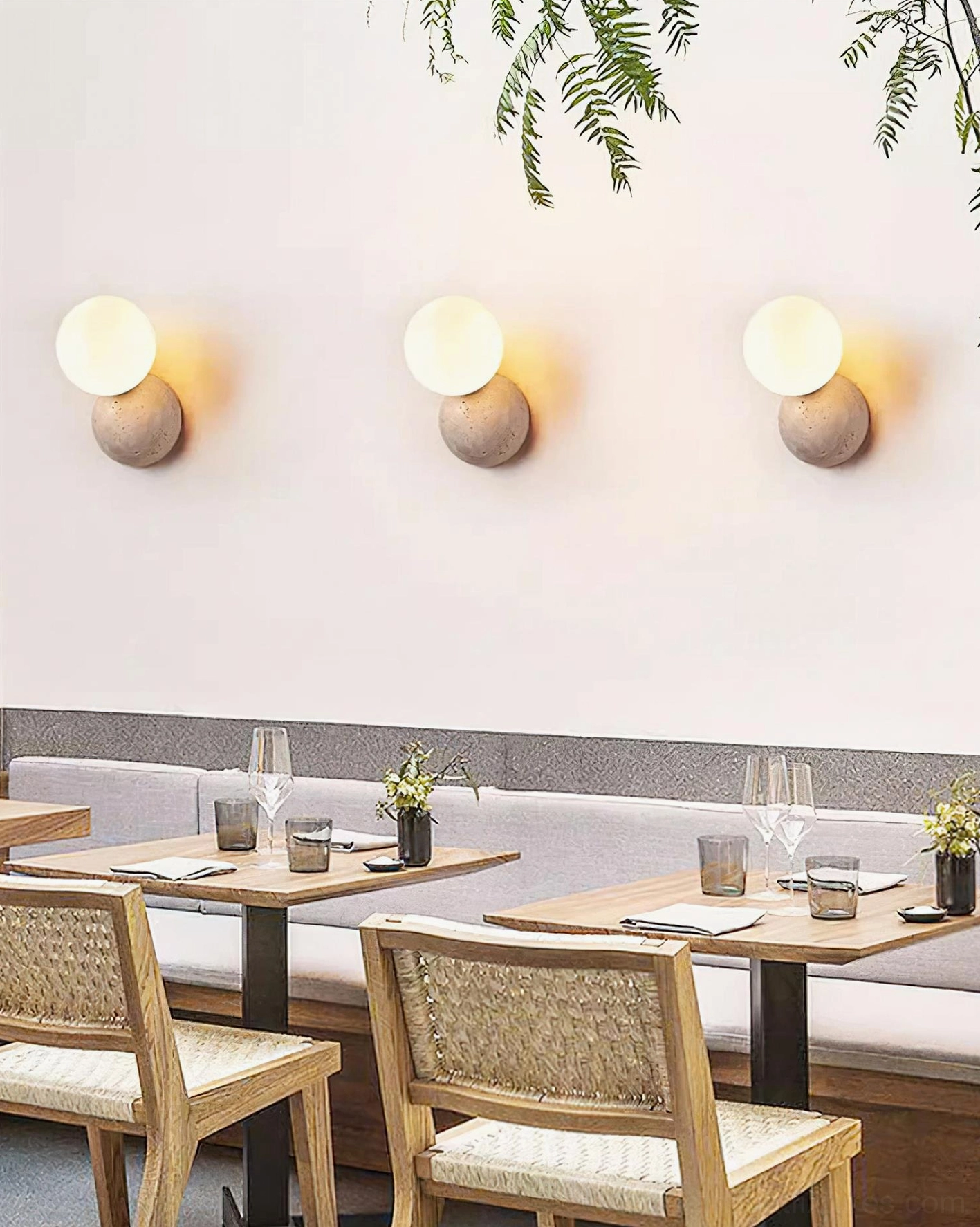 Three matching travertine wall sconces installed in commercial dining space, overhead restaurant lighting design