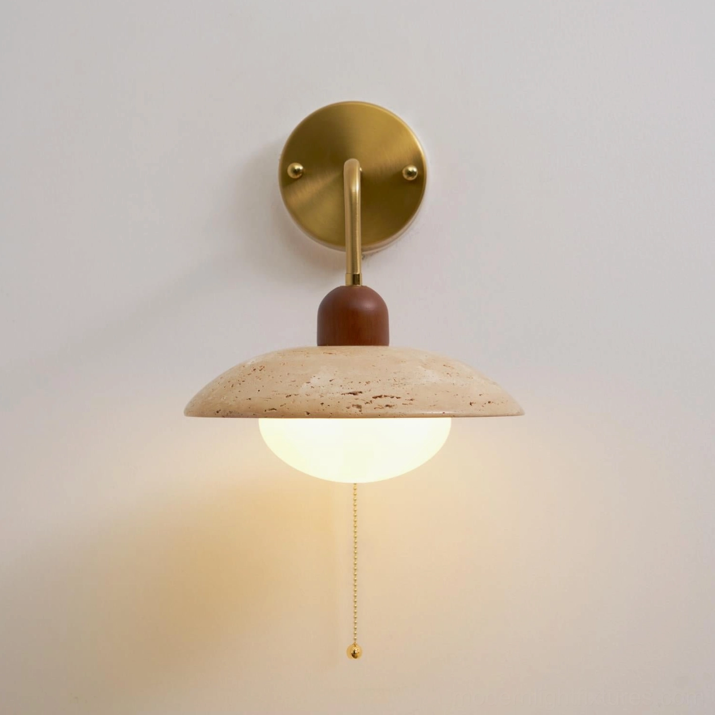 Detail view of travertine wall sconce showing natural stone texture and speckled finish characteristics