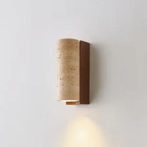 Modern travertine wall sconce casting warm ambient light on white wall - compact 2.5 inch width by 6.3 inch height size option