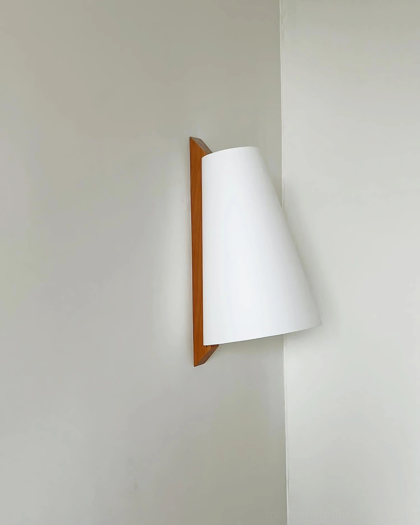 Trianora conical wall sconce side profile showing white fabric shade and warm brown mounting bracket in Japandi style