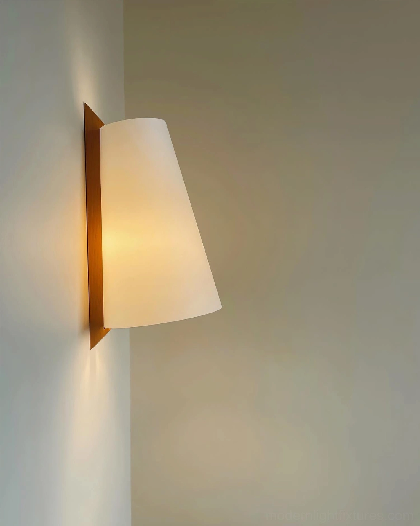 Trianora geometric wall sconce side profile illuminated against neutral off-white wall background