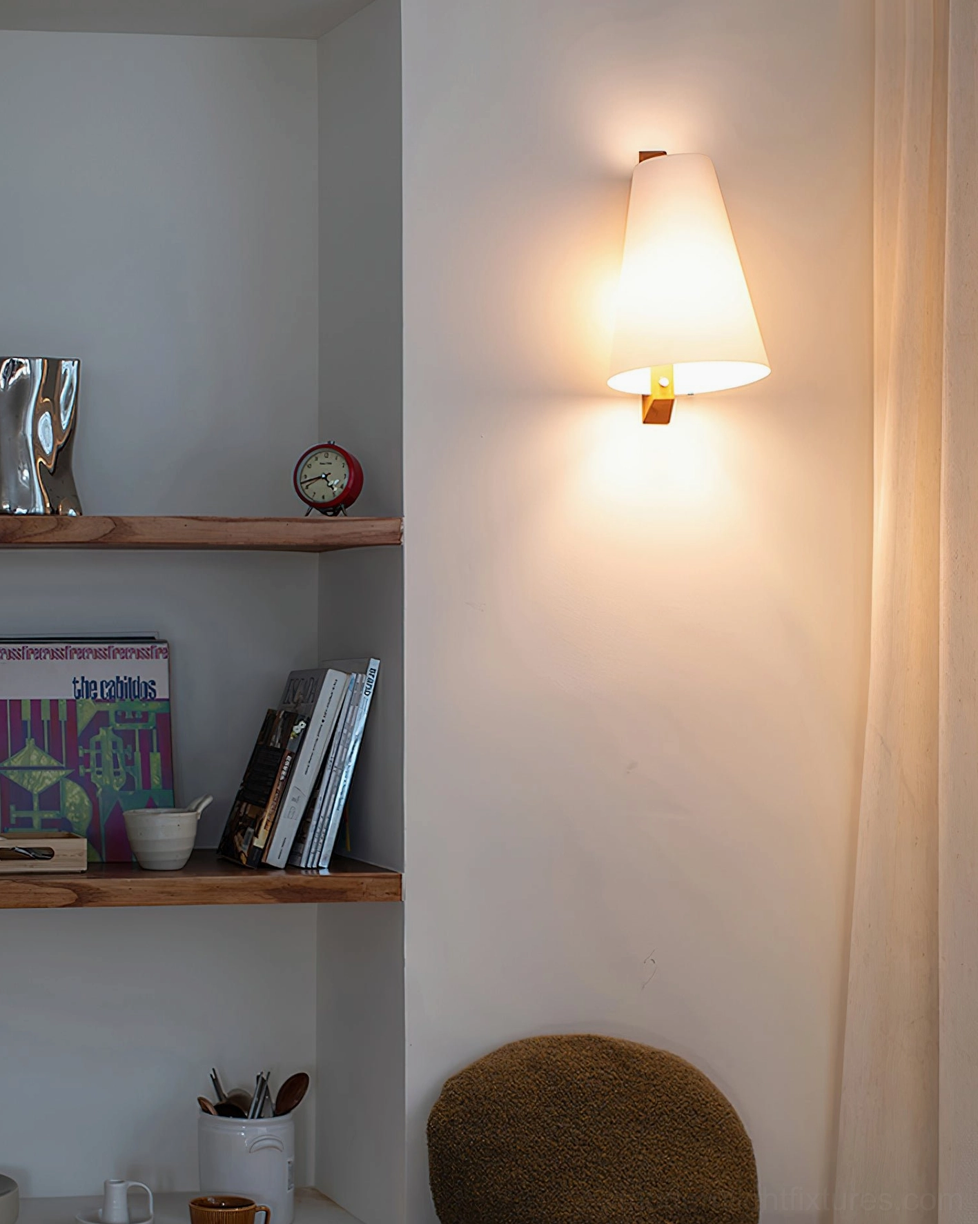 Lit Trianora minimalist wall sconce creating cozy lighting effect in study nook next to bookshelves