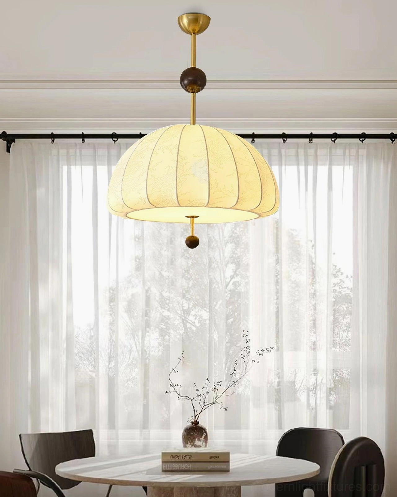 Trigg fabric pendant light hanging over round dining table with sheer curtains in dining room interior design