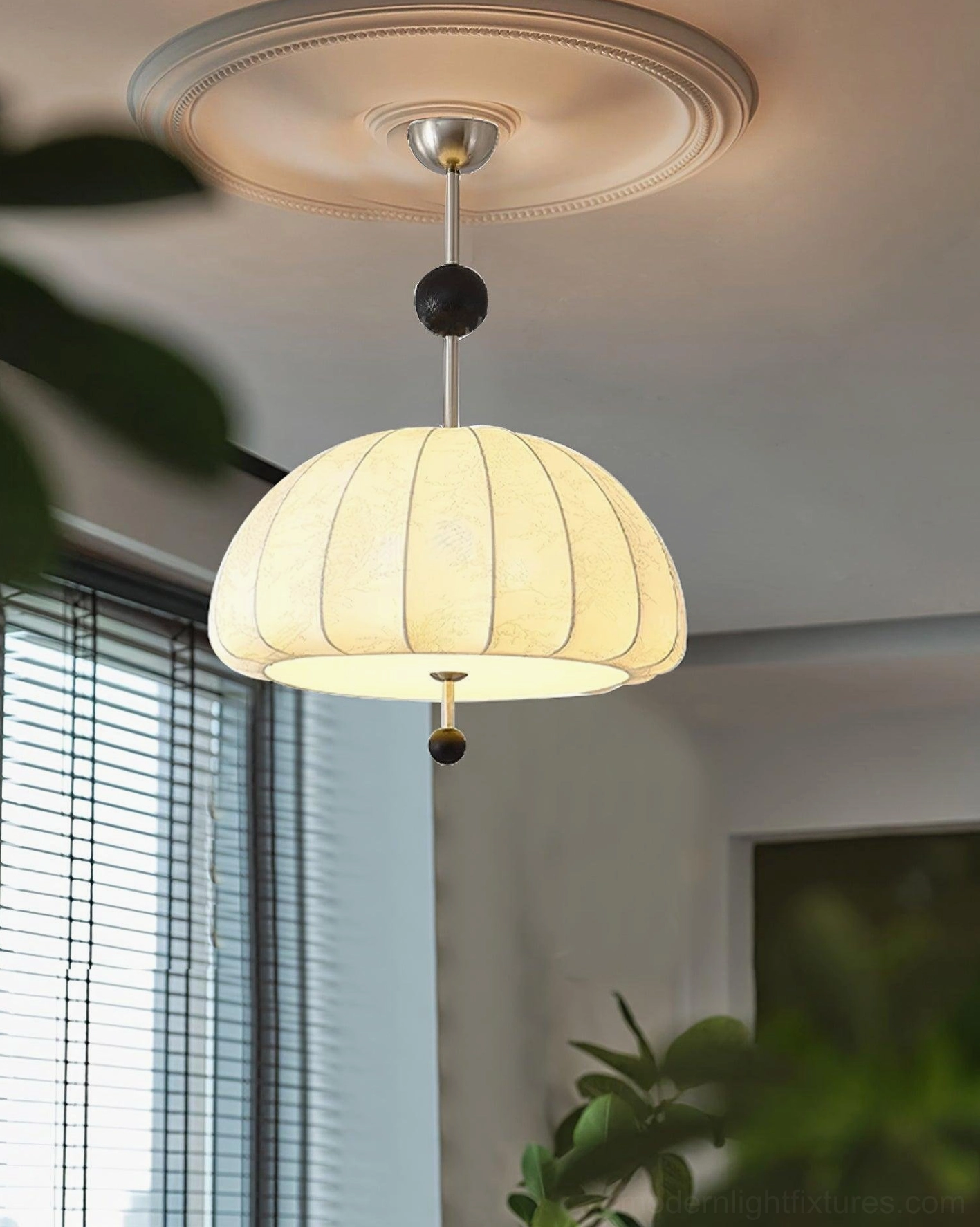 Trigg pendant light mounted on ceiling medallion in residential bedroom with ribbed fabric shade in warm interior lighting