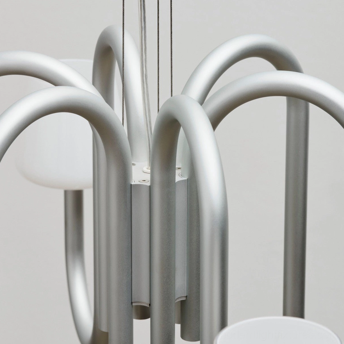 Contemporary Trilo chandelier installation showing adjustable hanging cable and symmetric arm configuration