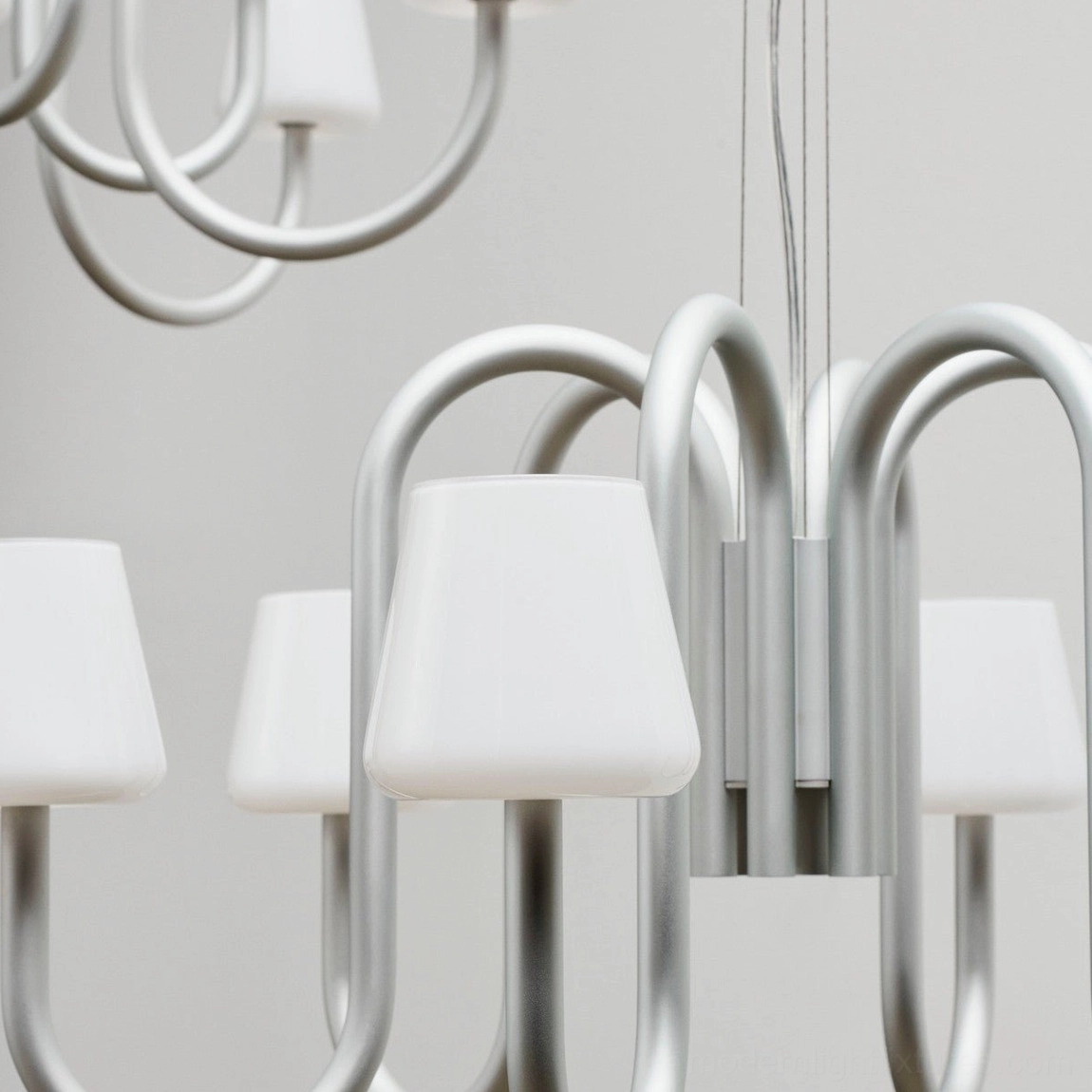 Trilo minimalist chandelier with clean lines and white glass shades in modern interior setting