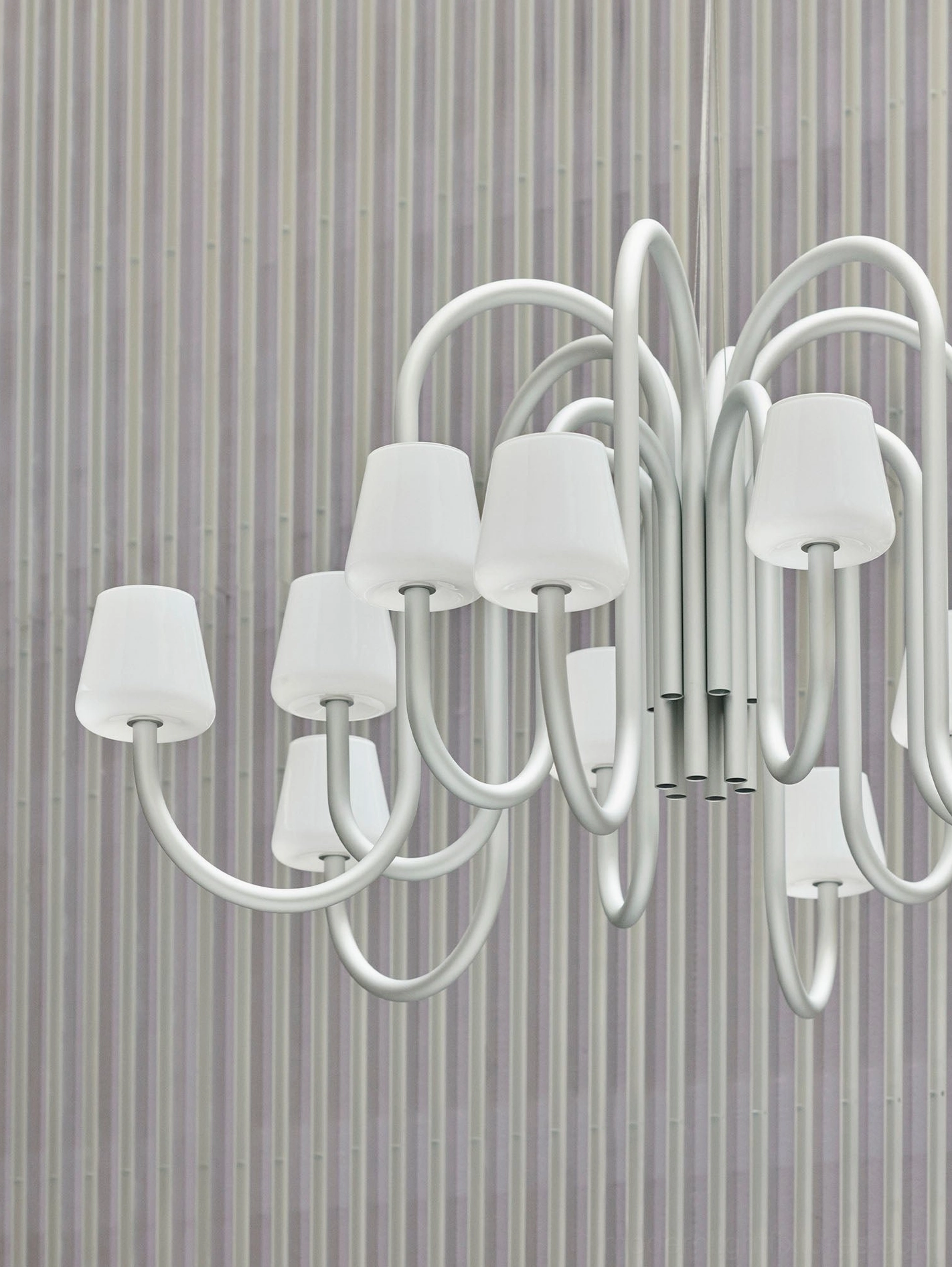 Close-up front view of Trilo sculptural chandelier with silver metal frame and opaque white glass shades