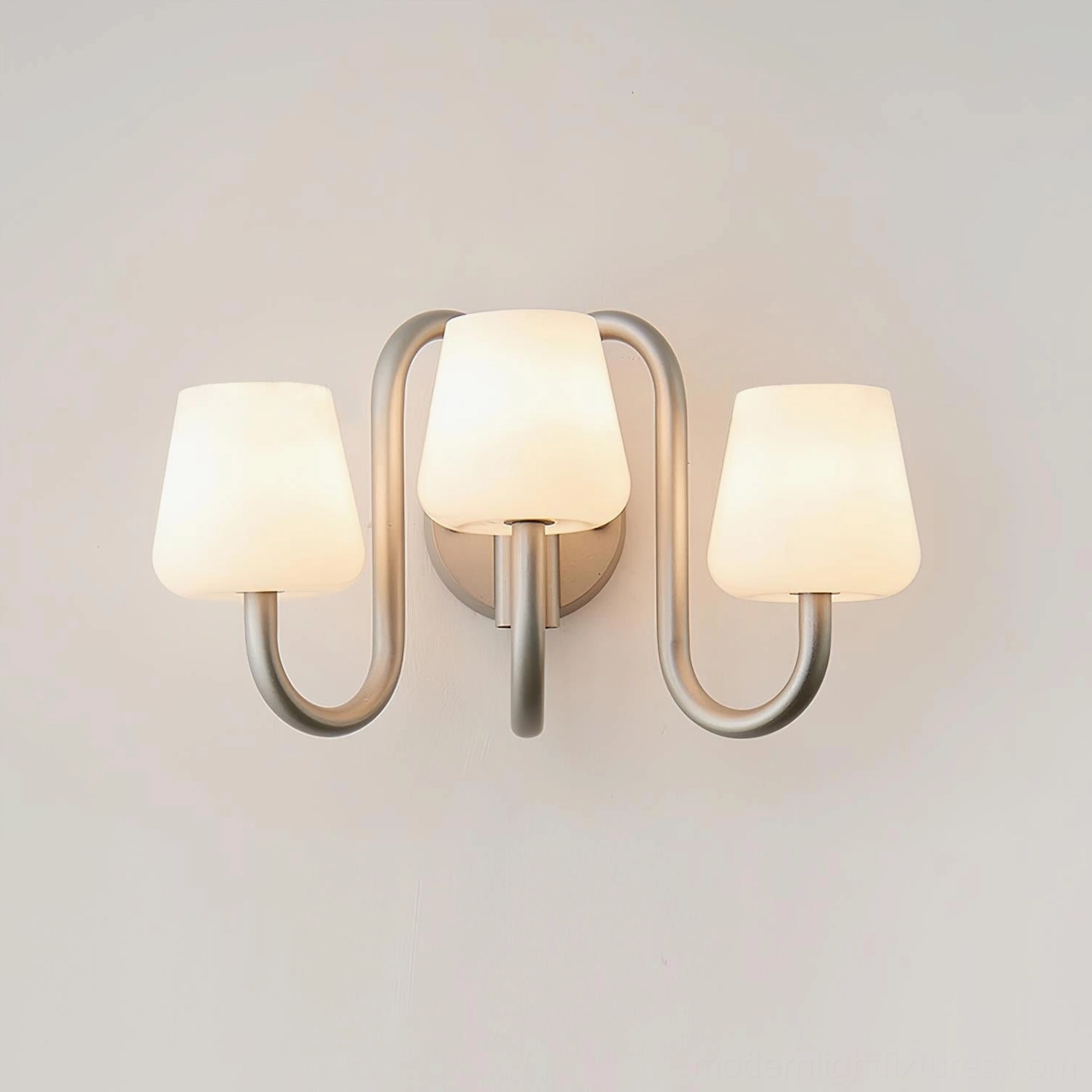 Trilo three-light wall lamp brightly lit showing all three frosted glass shades glowing together