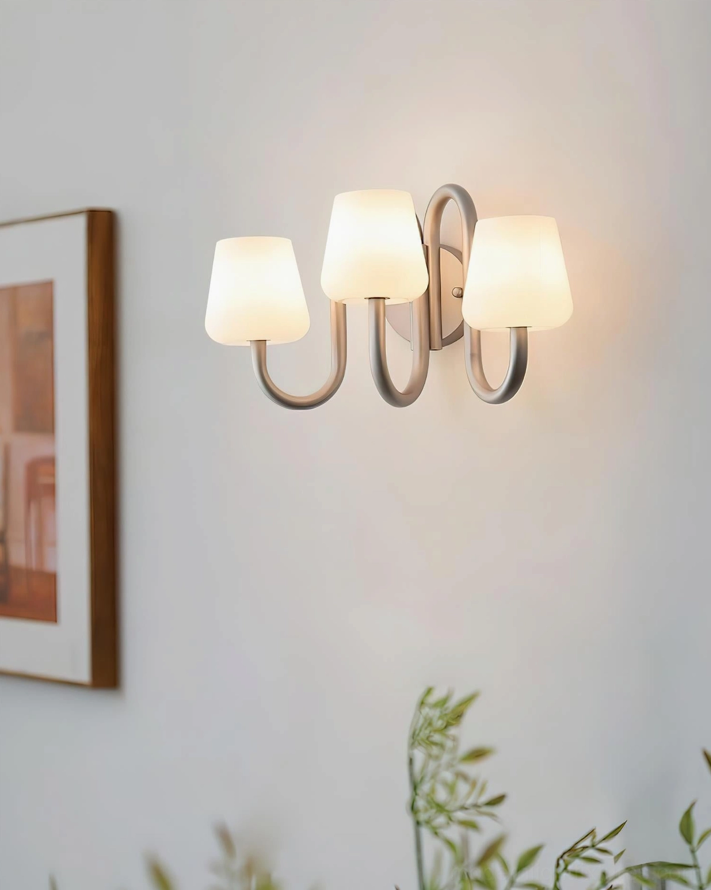 Trilo 3-light wall sconce mounted in home interior with wall art and plants, modern room setting