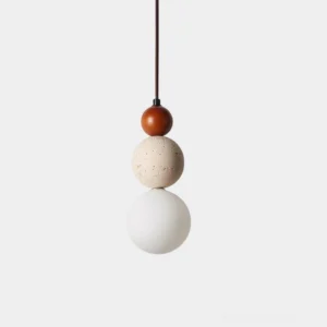 Trio Orb pendant light with stacked wood, travertine, and frosted glass spheres in studio minimalist setting